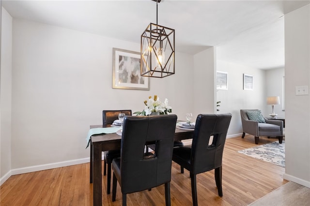 dining area featuring hardwood / wood-style flooring and an inviting chandelier