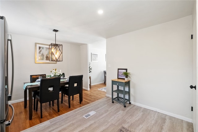 dining room with a chandelier and light hardwood / wood-style flooring