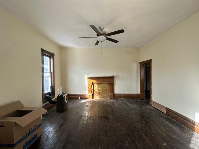 unfurnished living room featuring ceiling fan and dark hardwood / wood-style floors