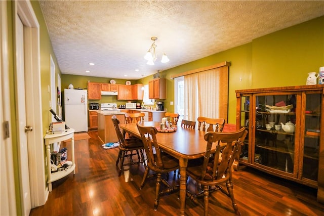 dining space featuring dark hardwood / wood-style flooring, a notable chandelier, and a textured ceiling