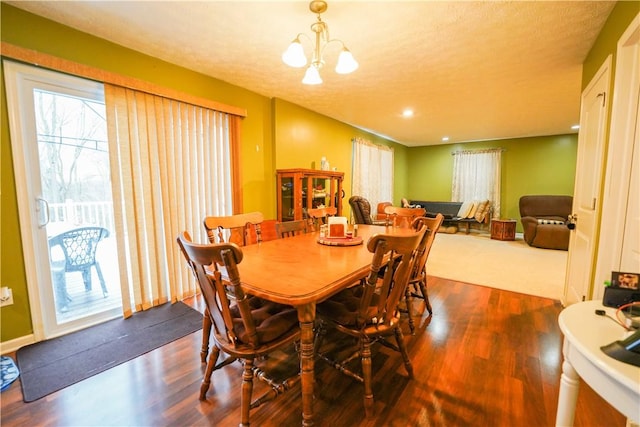 dining room featuring dark hardwood / wood-style flooring, a textured ceiling, and a chandelier