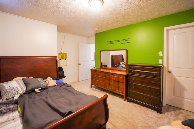 bedroom with light carpet and a textured ceiling