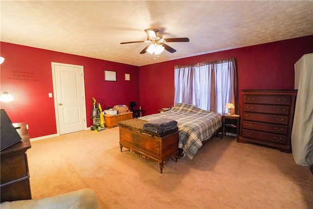 carpeted bedroom with ceiling fan and a textured ceiling