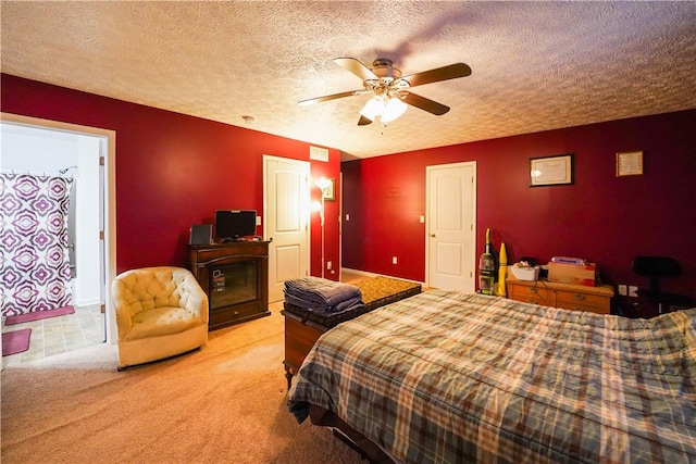 bedroom featuring light carpet, a textured ceiling, and ceiling fan