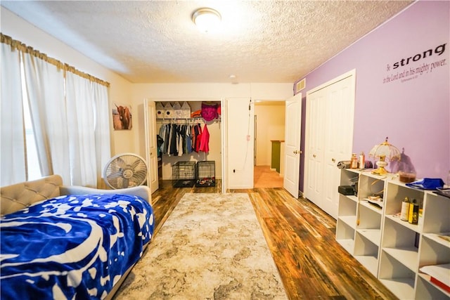 bedroom with dark hardwood / wood-style floors and a textured ceiling