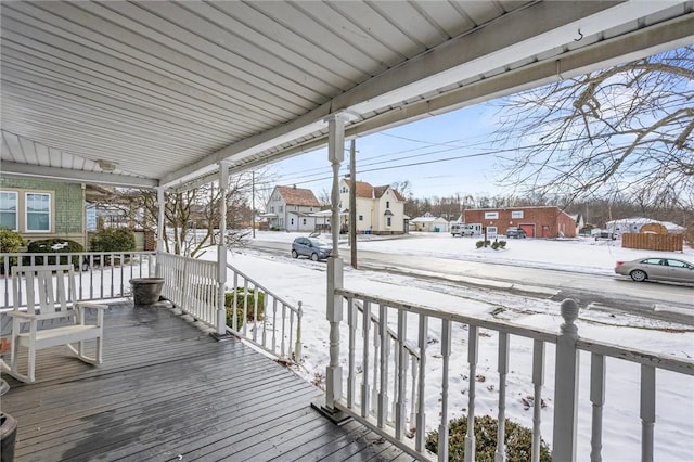 snow covered deck featuring covered porch