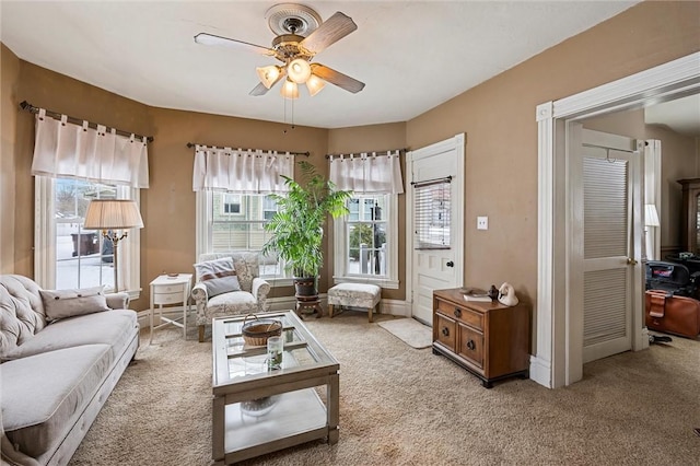 carpeted living room with ceiling fan