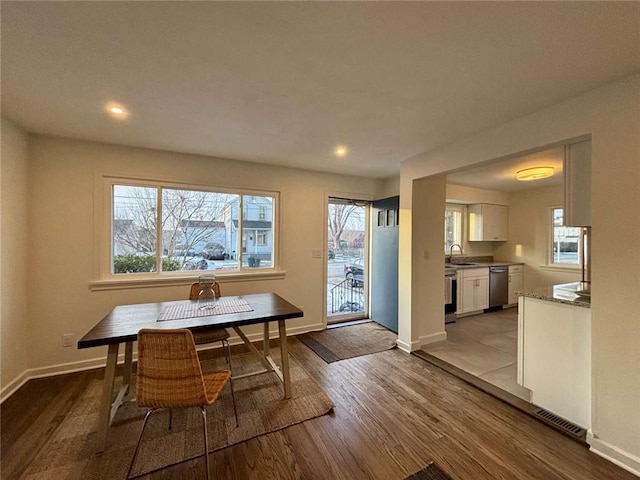 dining space with sink and light wood-type flooring