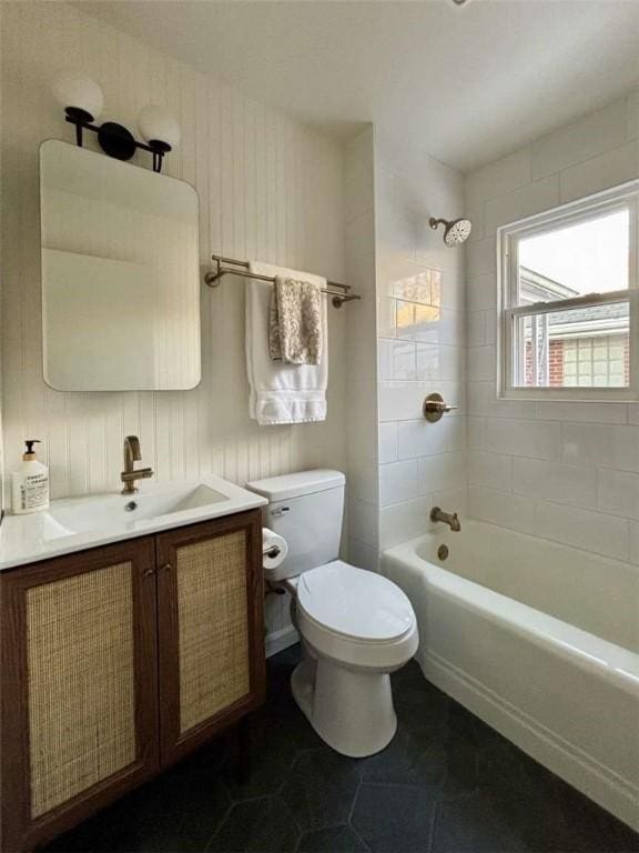 full bathroom featuring tiled shower / bath, vanity, and toilet