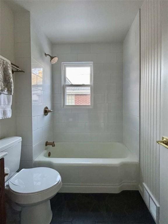 full bathroom with tiled shower / bath, vanity, and toilet