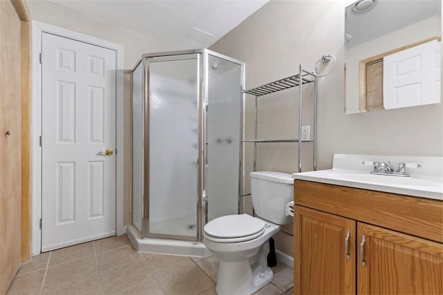 bathroom featuring vanity, toilet, a shower with shower door, and tile patterned flooring