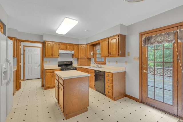 kitchen with sink, black appliances, and a kitchen island