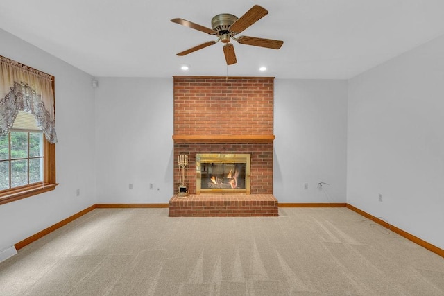 unfurnished living room featuring ceiling fan, a fireplace, and carpet flooring