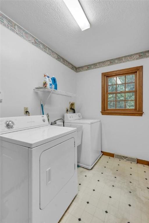 laundry room with washer and dryer and a textured ceiling