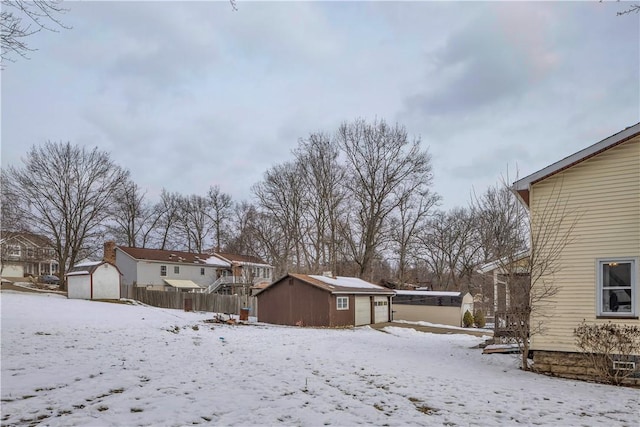 yard covered in snow featuring a storage unit