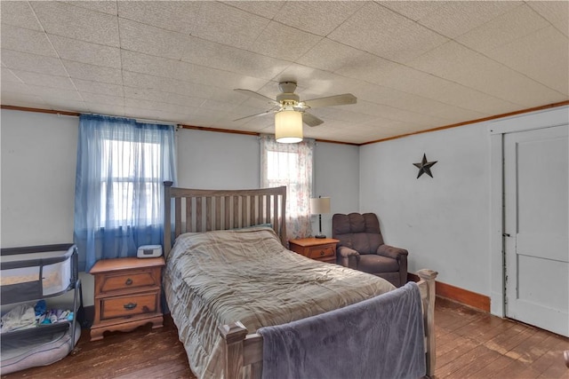 bedroom with crown molding, ceiling fan, and dark hardwood / wood-style flooring