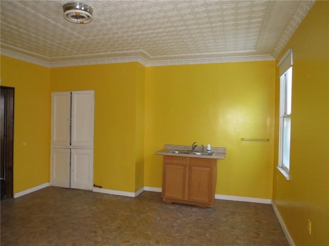 empty room featuring ornamental molding and sink