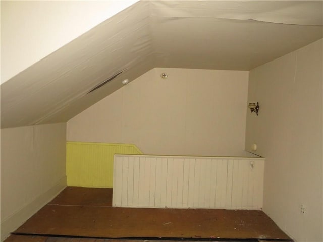 additional living space featuring lofted ceiling and radiator