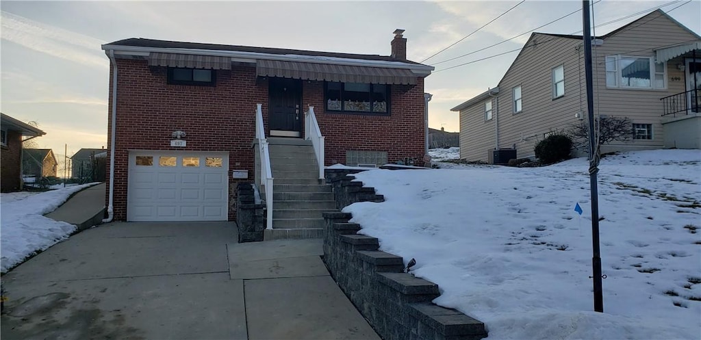 view of front of home with central AC and a garage