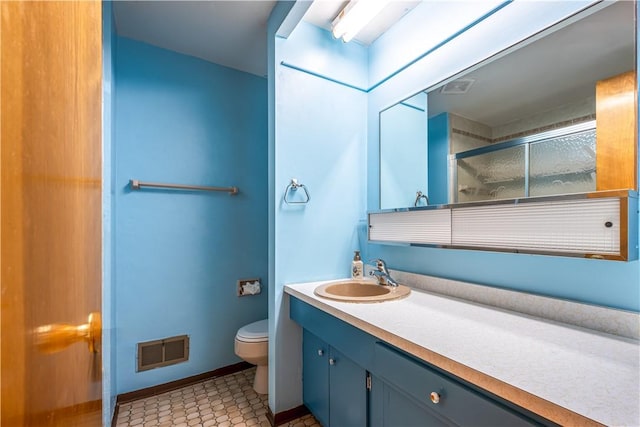 bathroom with vanity, toilet, and an enclosed shower