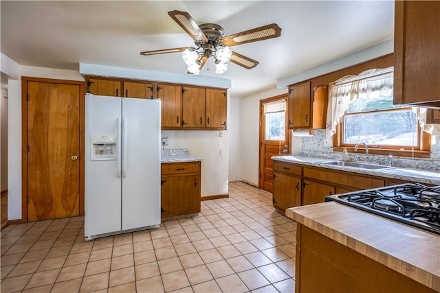 kitchen with ceiling fan, white refrigerator with ice dispenser, sink, and light tile patterned floors