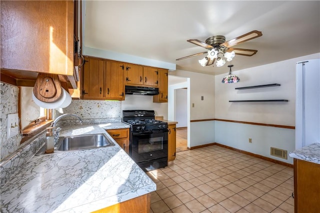 kitchen with sink, backsplash, light tile patterned floors, ceiling fan, and gas stove