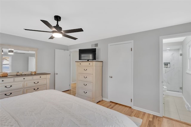 bedroom featuring ceiling fan, ensuite bathroom, and light wood-type flooring