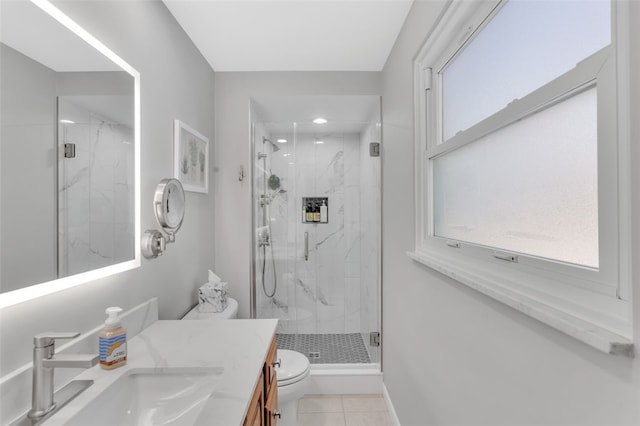 bathroom featuring tile patterned flooring, vanity, toilet, and walk in shower