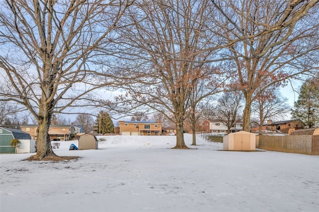 yard layered in snow with a storage unit