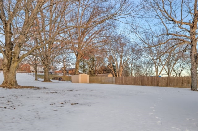 yard layered in snow featuring a shed