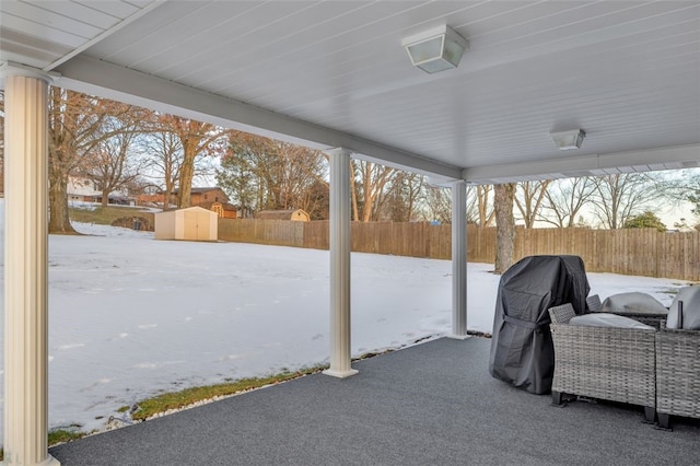 snow covered patio with a shed