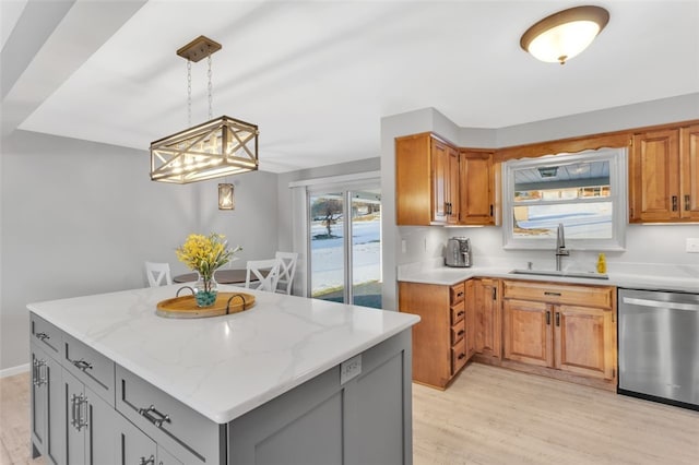 kitchen with sink, gray cabinets, a center island, light stone counters, and stainless steel dishwasher