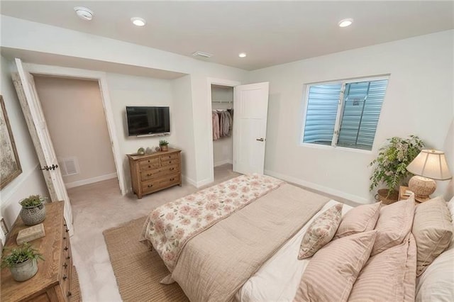 bedroom featuring a spacious closet, light colored carpet, and a closet