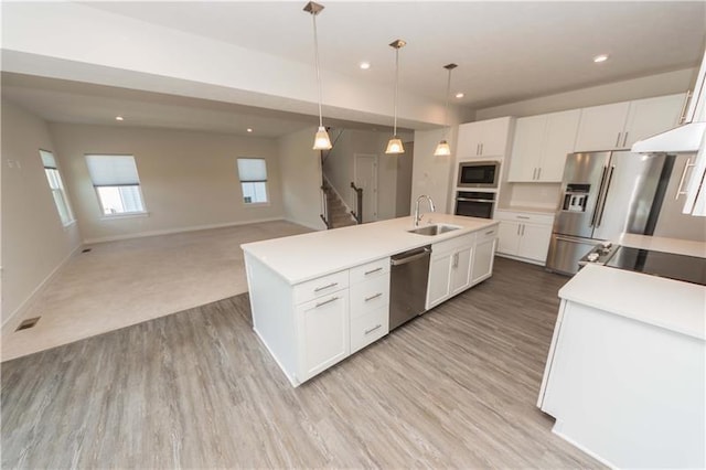 kitchen with stainless steel appliances, white cabinetry, hanging light fixtures, and sink