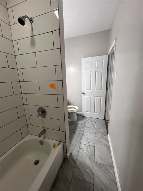 bathroom with toilet and tiled shower / bath combo