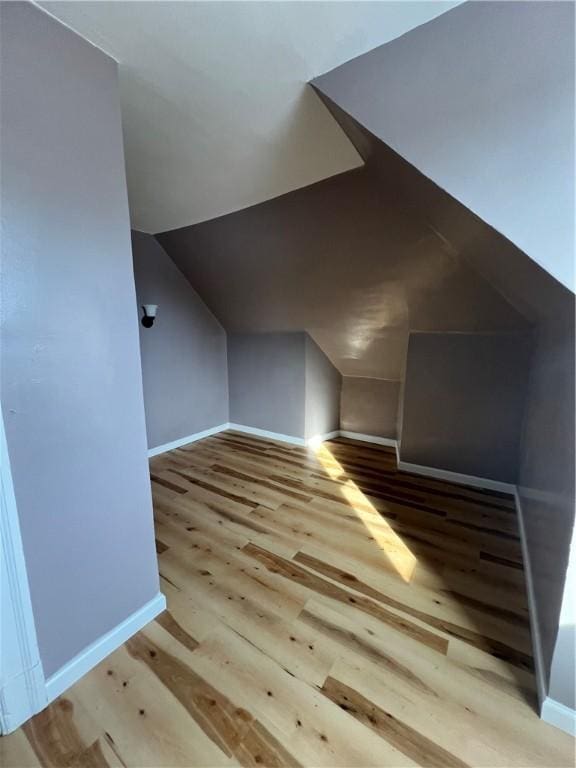 bonus room featuring lofted ceiling and light wood-type flooring