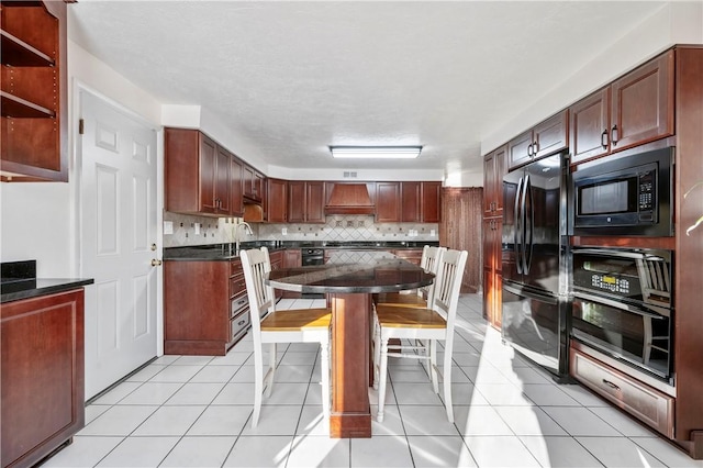 kitchen with premium range hood, light tile patterned floors, decorative backsplash, and black appliances