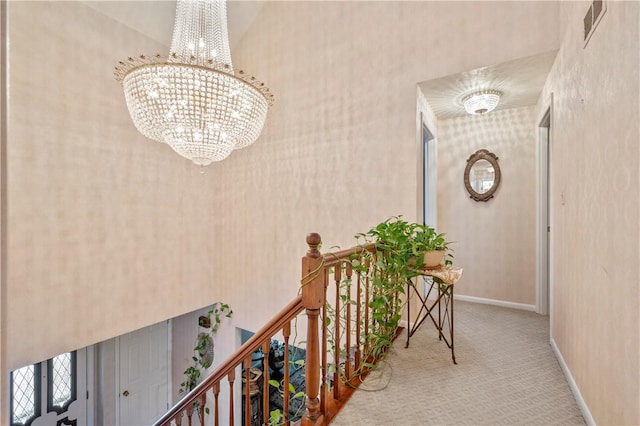 hall with carpet and an inviting chandelier