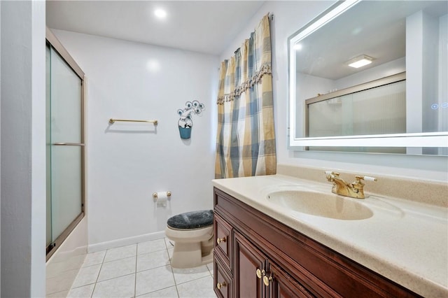 full bathroom with tile patterned flooring, vanity, bath / shower combo with glass door, and toilet