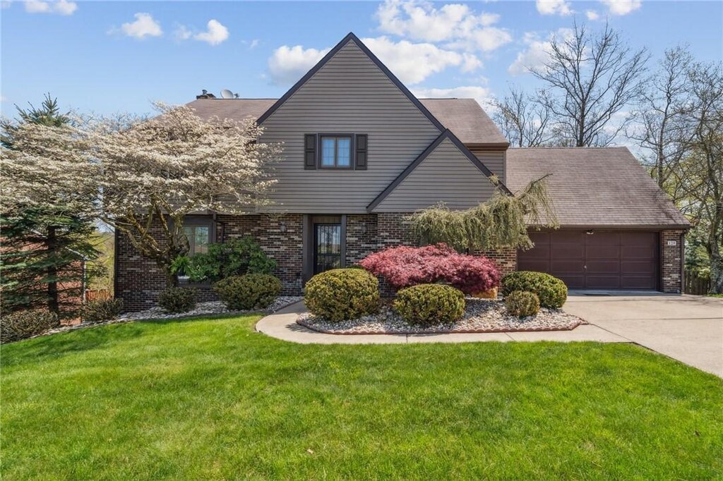 129 Regal Ct, Monroeville, PA 15146 - view of front of home featuring concrete driveway, a garage, a front lawn, and brick siding