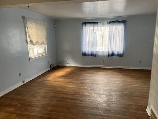 unfurnished room featuring dark hardwood / wood-style floors and a wealth of natural light