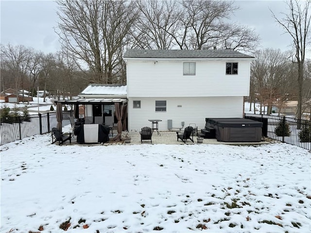 snow covered property with a hot tub