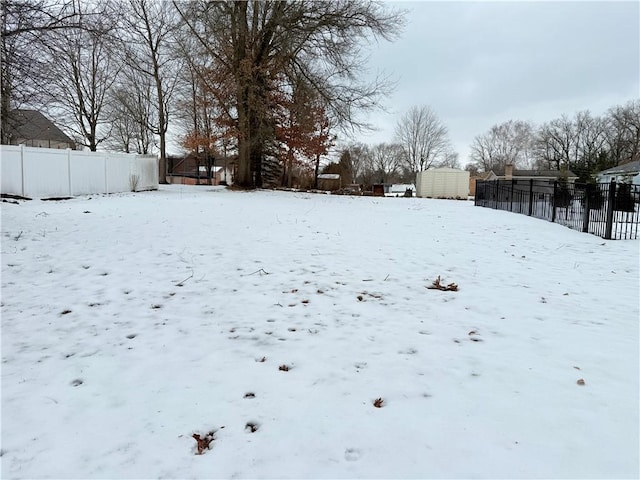 snowy yard with a storage shed