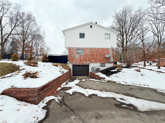 view of snowy exterior with a garage