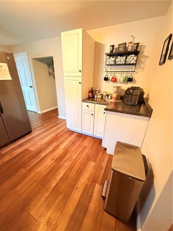 bar featuring white cabinetry and light hardwood / wood-style flooring