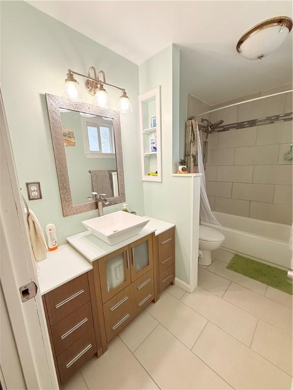 full bathroom with shower / tub combo, vanity, tile patterned flooring, and toilet