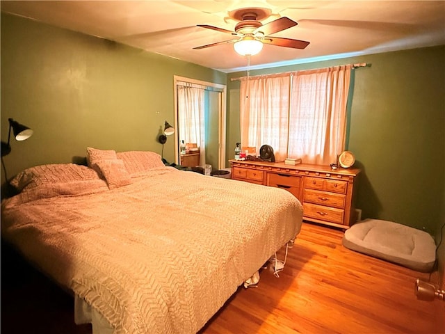 bedroom with light hardwood / wood-style flooring, a closet, and ceiling fan