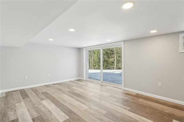 unfurnished room with lofted ceiling and light wood-type flooring