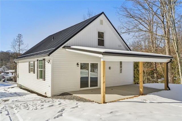 view of snow covered rear of property