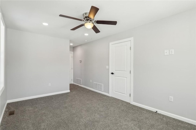 empty room featuring dark carpet and ceiling fan